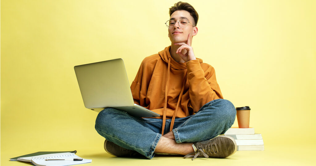 man studying with laptop cross sitting on the floor